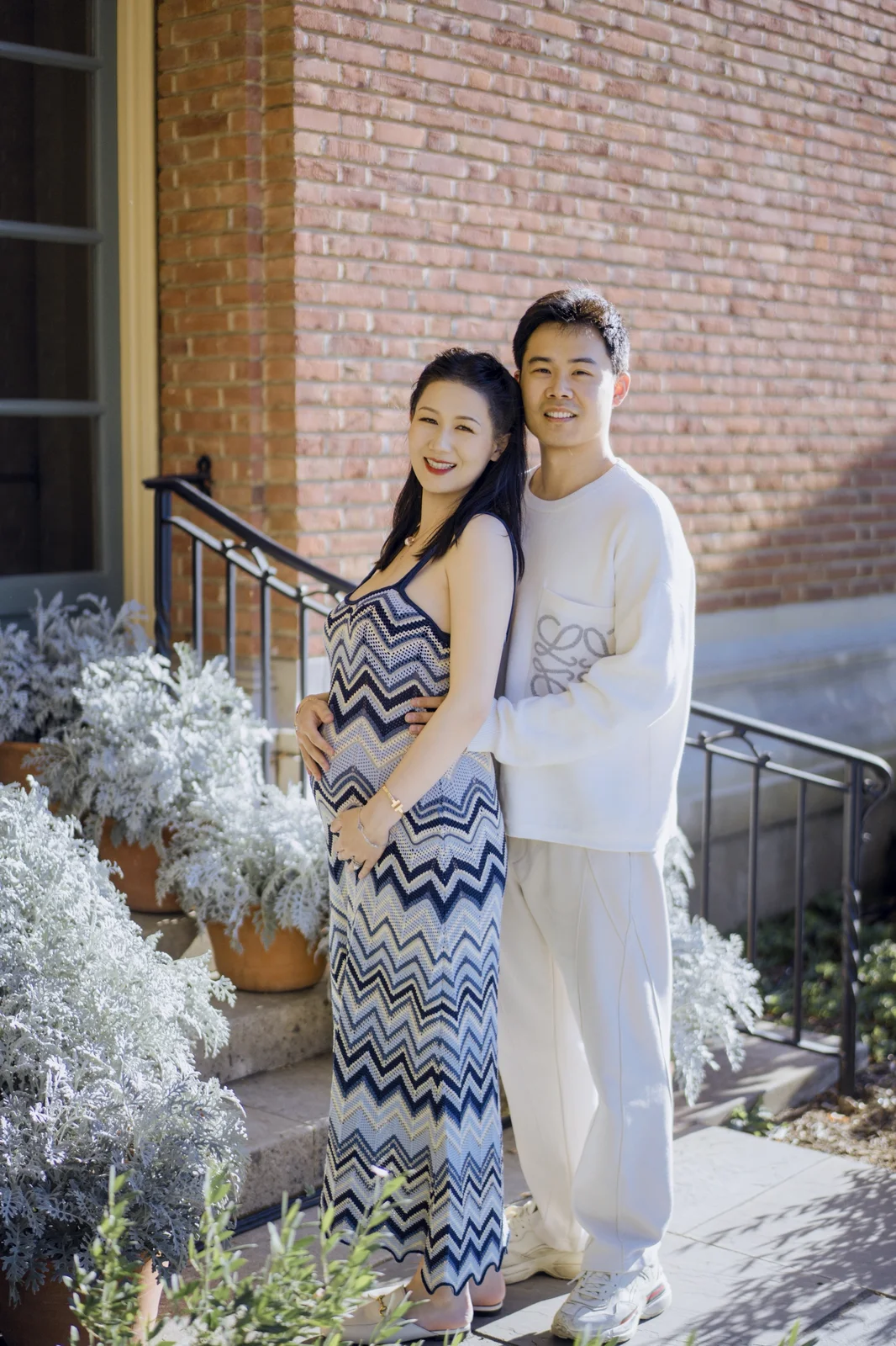 Expecting mother holding white flowers during a soft studio maternity session