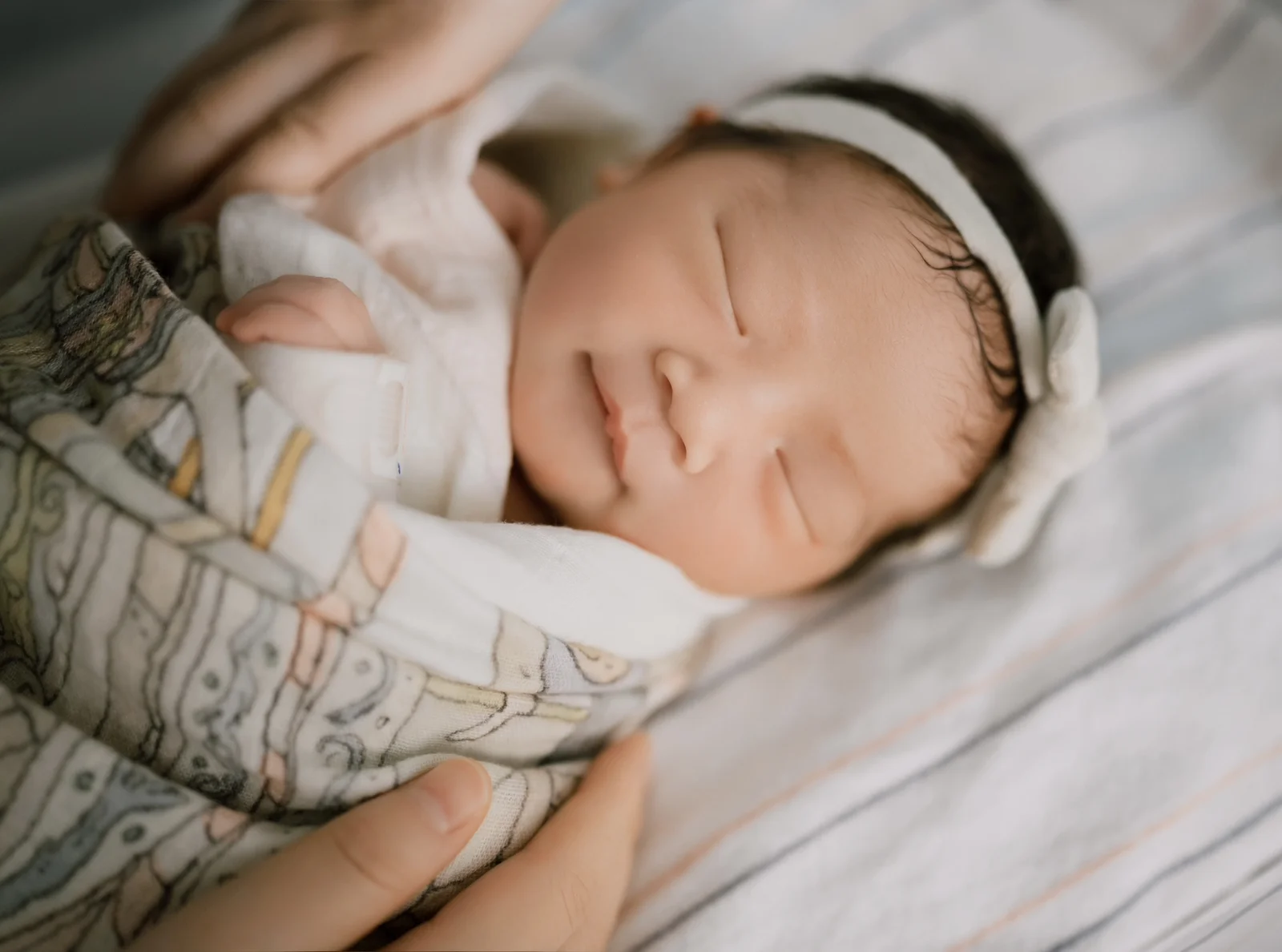 Family gathered around their newborn baby during a soft indoor newborn session