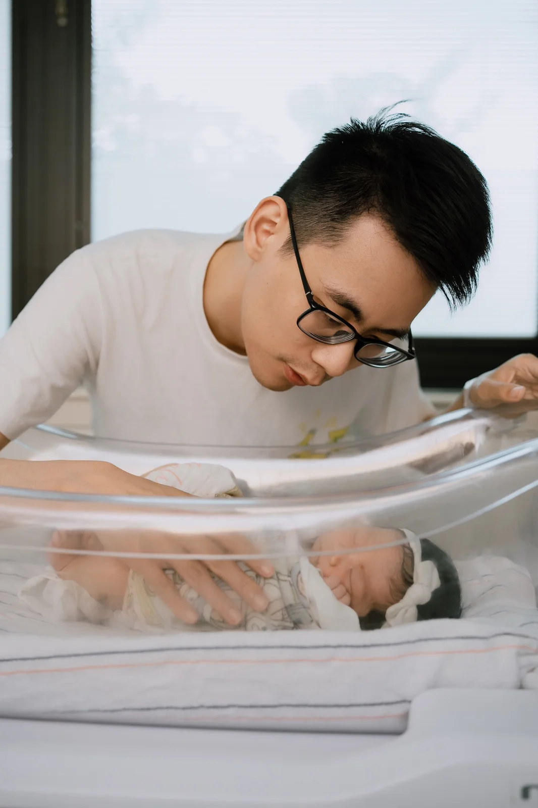 Parents cuddling their newborn baby during a soft indoor newborn session