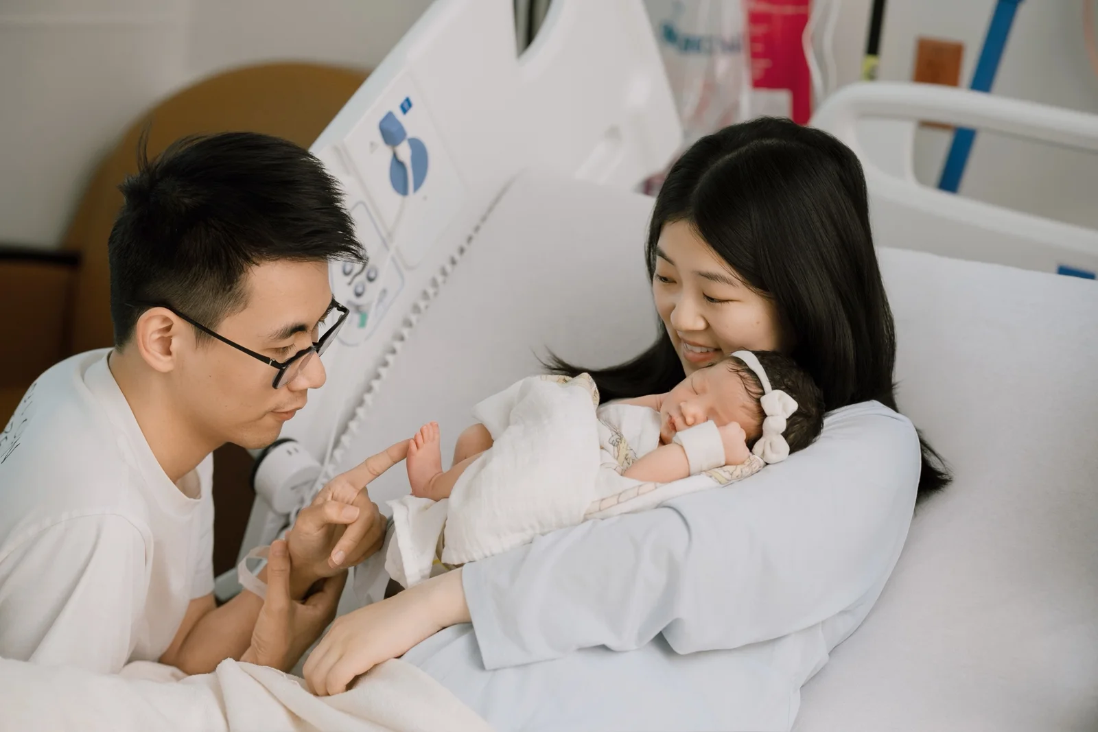 Mother holding her newborn baby in a bright nursery during an in-home newborn session