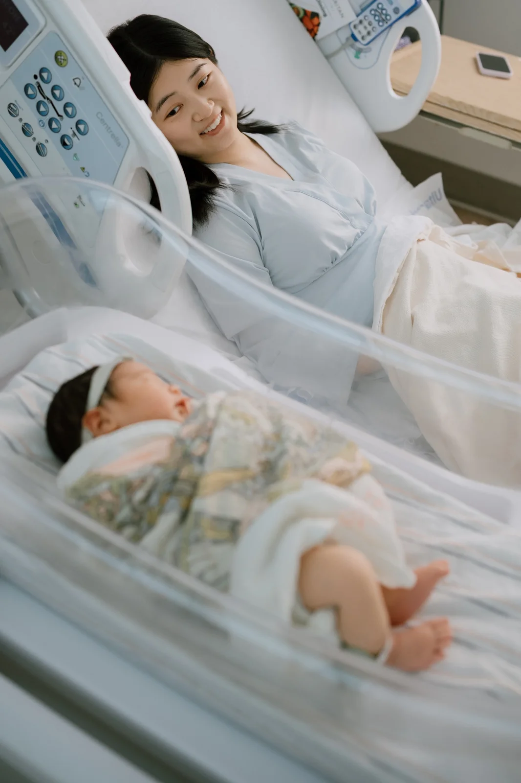 Parents sitting on floor in master bedroom holding baby