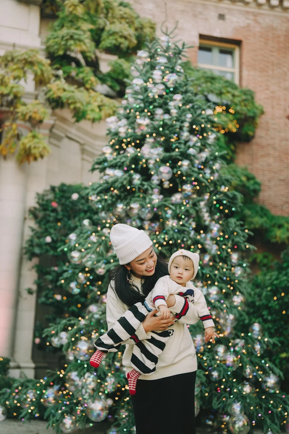 Mother and toddler portrait under blooming cherry blossoms during a Seattle spring family session